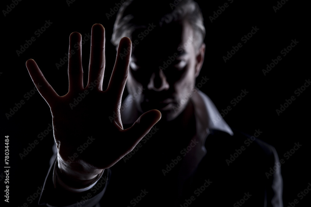 Men's silhouette in the dark shows the stop hand Men's silhouette in the dark shows the stop hand