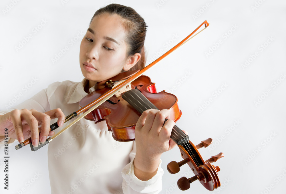 Beautiful young woman playing violin over white background Beautiful young woman playing violin over white background