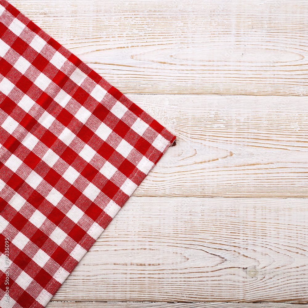 Top view of checkered tablecloth on white wooden table. Top view of checkered tablecloth on white wooden table.