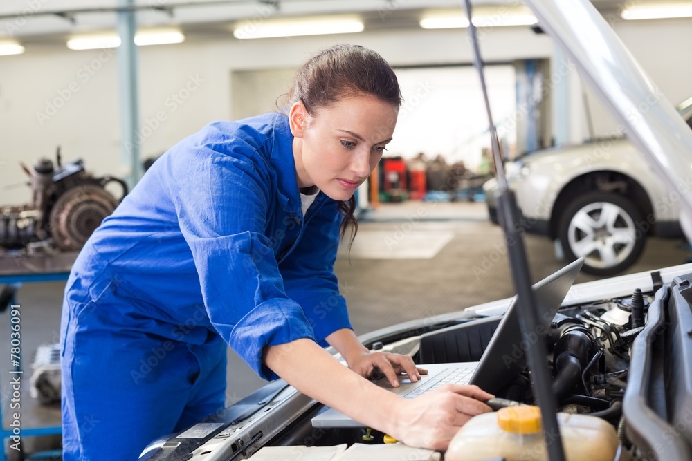 Mechanic using laptop on car Mechanic using laptop on car