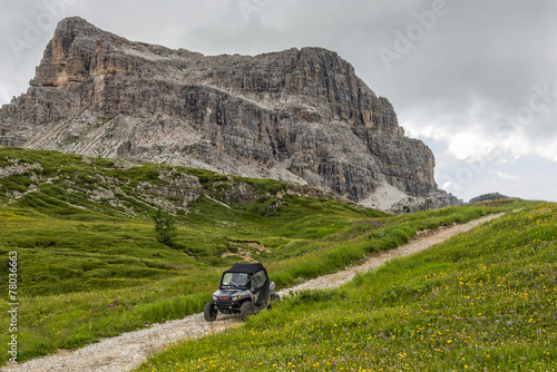 Dune buggy on a trail in the meadows, Dolomites, Italy photo