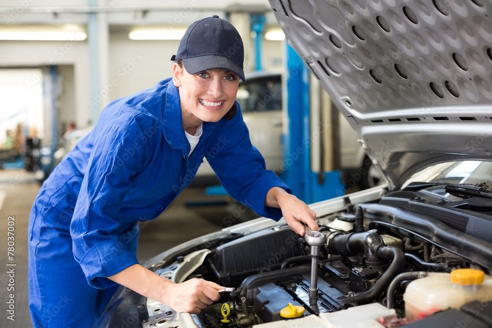Smiling mechanic working on car Smiling mechanic working on car