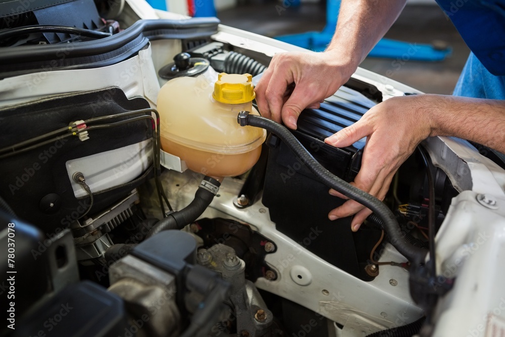 Mechanic working under the hood Mechanic working under the hood
