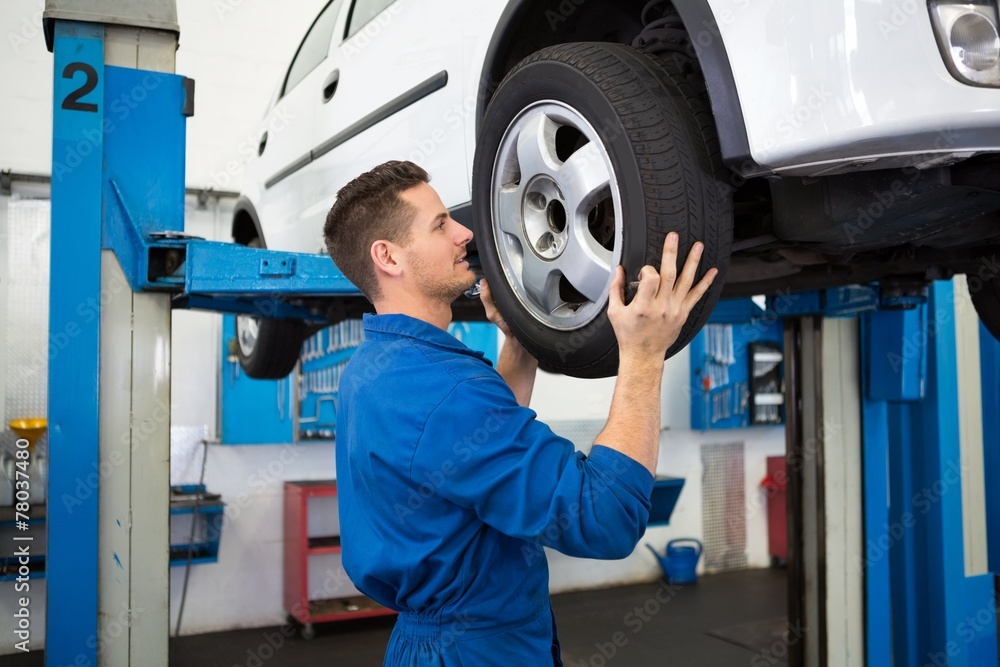 Fototapeta premium Mechanic adjusting the tire wheel