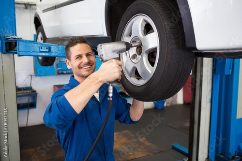 Mechanic adjusting the tire wheel © WavebreakmediaMicro