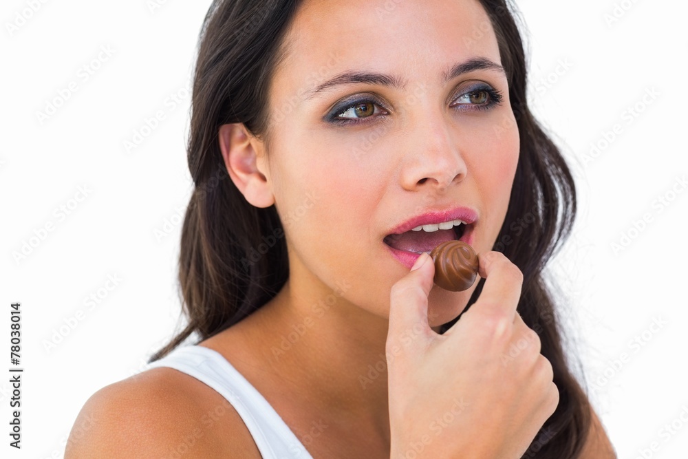 Pretty brunette eating chocolate candy Pretty brunette eating chocolate candy