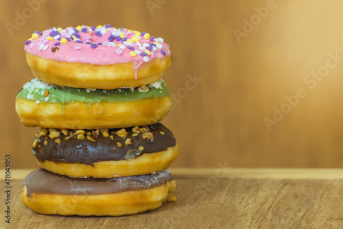 various glazed donuts isolate on wooden background.
