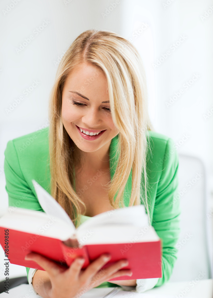 smiling young woman reading book at school smiling young woman reading book at school