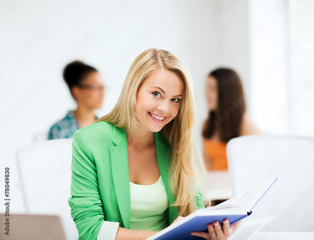smiling student girl reading book at school smiling student girl reading book at school