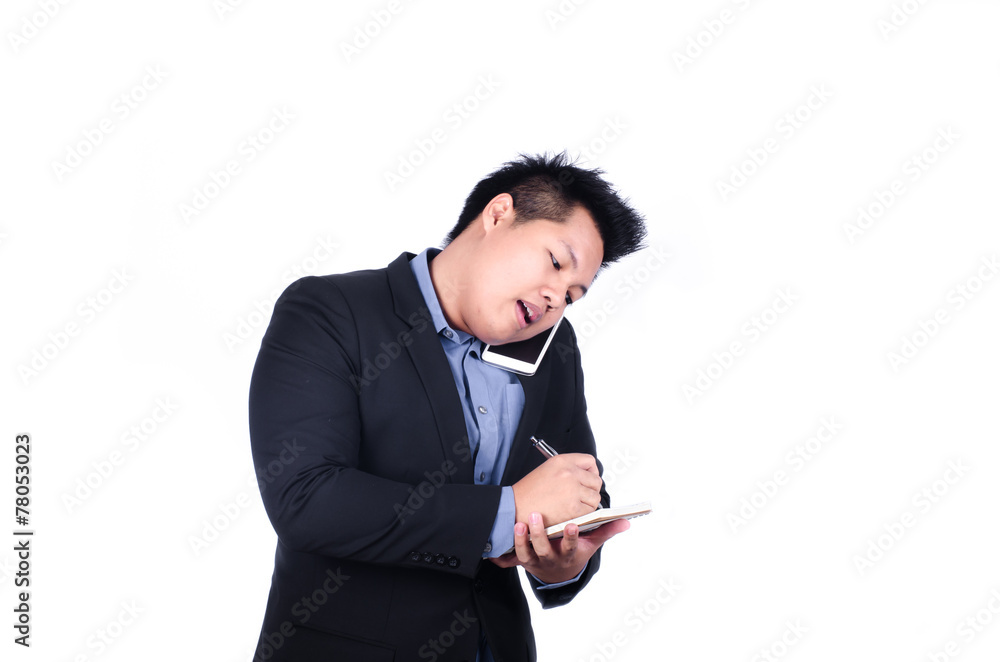 Asian business man on phone and taking notes Asian business man on phone and taking notes