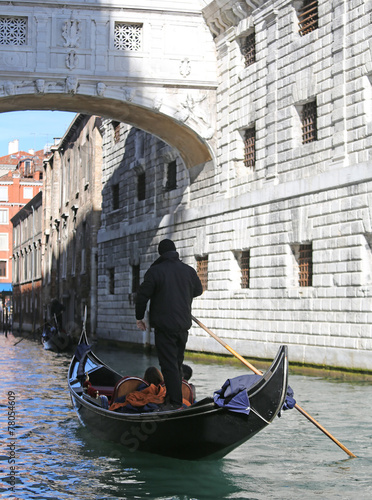 Gondolier on channel of the bridge of sighs in Venice