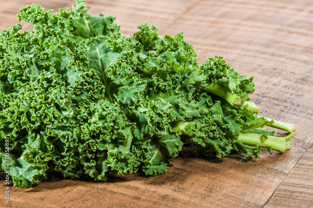Curly kale leaves on wooden table Curly kale leaves on wooden table