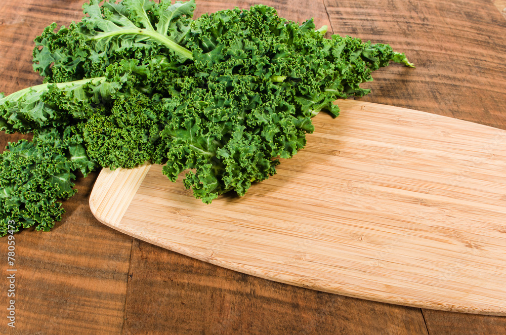 Curly kale leaves on cutting board Curly kale leaves on cutting board