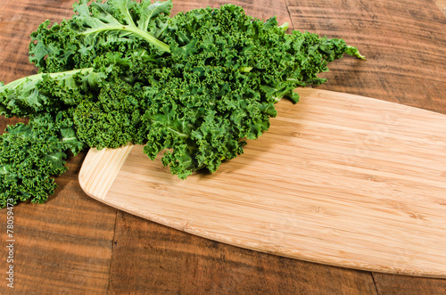 Curly kale leaves on cutting board