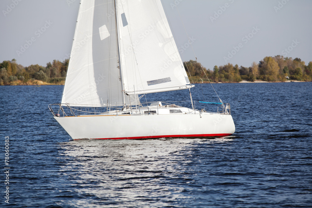 Sailing yacht at the river bank in autumn