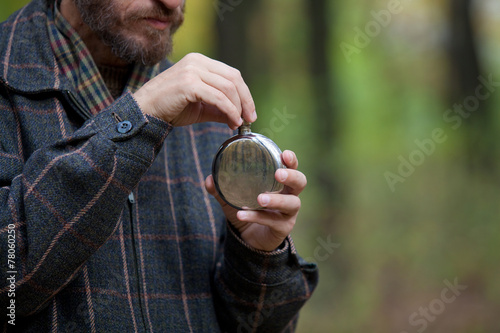 Man with beard opens the flask photo