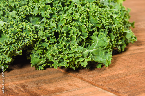 Curly kale leaves on wooden table