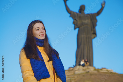 Young girl dressed in Ukrainian national colors against blue sky