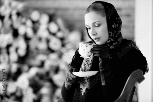 Winter portrait of the girl in traditional scarf with cap of tea