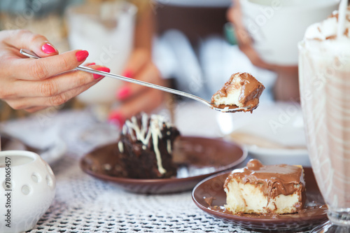 Female hand holding a piece of cake on a spoon