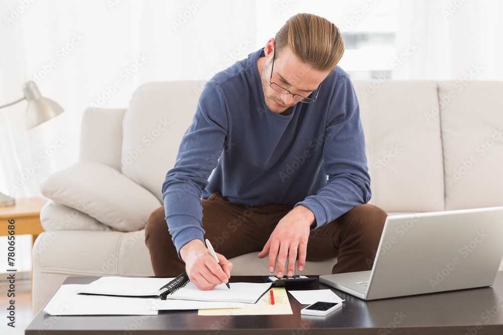 Concentrated man using calculator counting his bills Concentrated man using calculator counting his bills