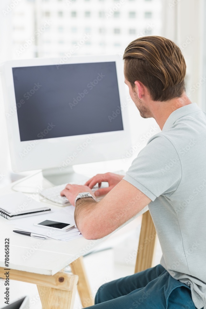 Rear view of businessman typing on keyboard