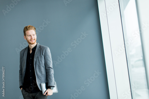 Man with tablet by the wall