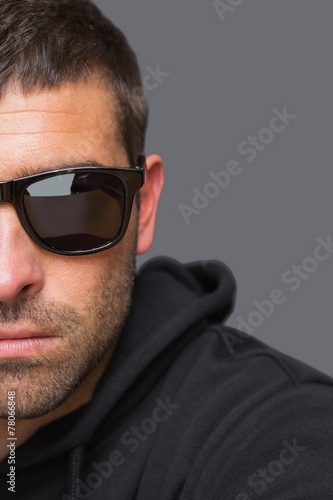 Criminal with sunglasses looking at camera