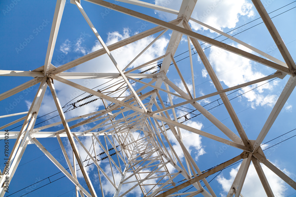 Bottom view power transmission lines against blue sky Bottom view power transmission lines against blue sky