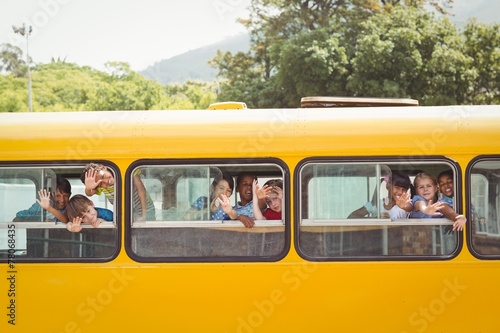 Cute pupils smiling at camera in the school bus