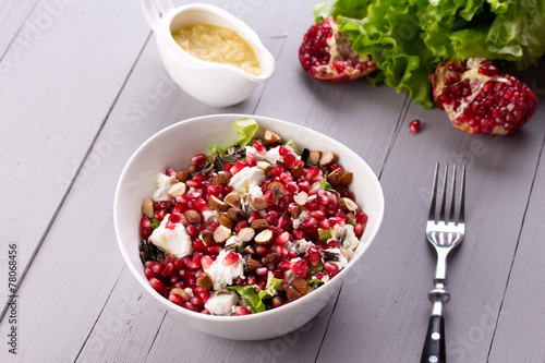 Healthy salad with pomegranate seeds, almond, feta cheese and