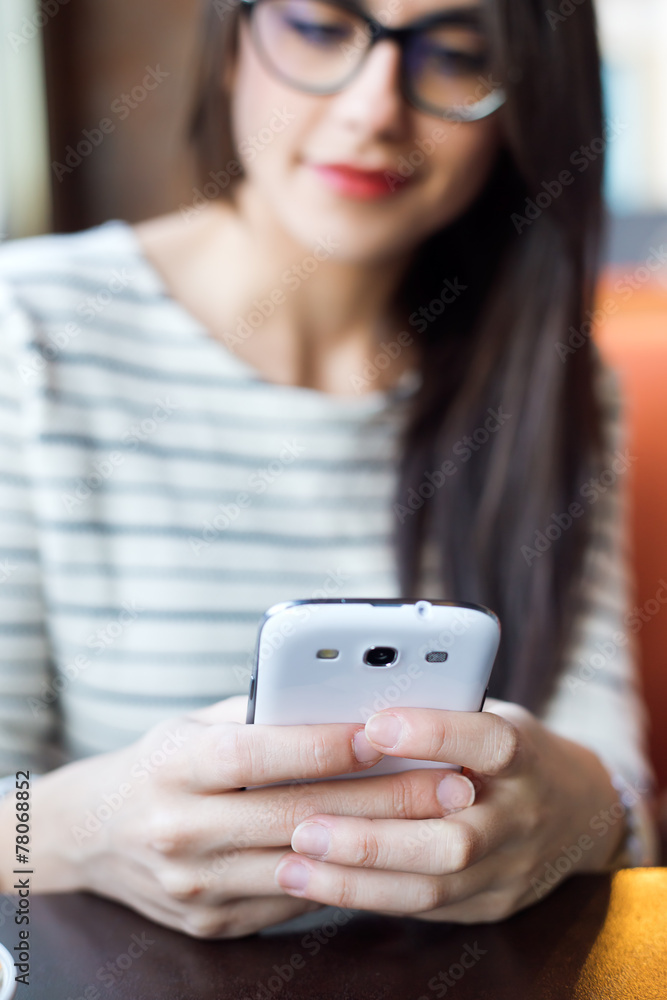 Young beautiful woman using her mobile phone in coffee. Young beautiful woman using her mobile phone in coffee.