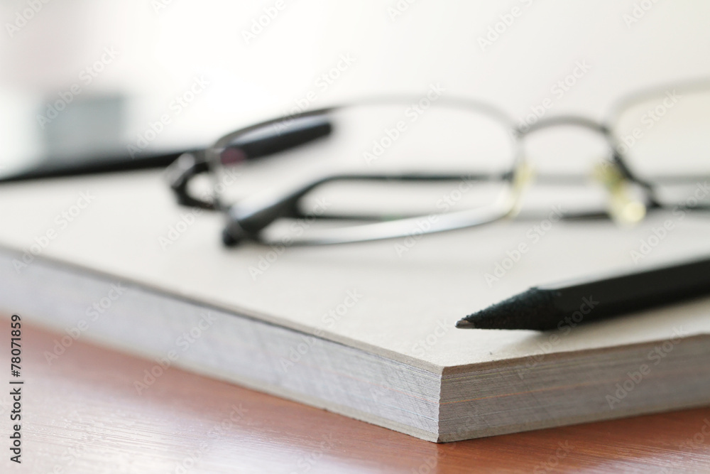 close up of Blank notepad with pencil on office wooden table close up of Blank notepad with pencil on office wooden table