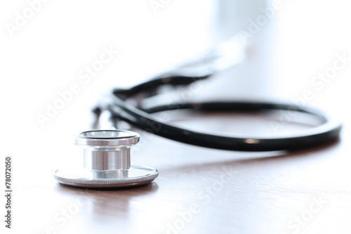 Stethoscope with digital tablet computer on wooden table and  ba