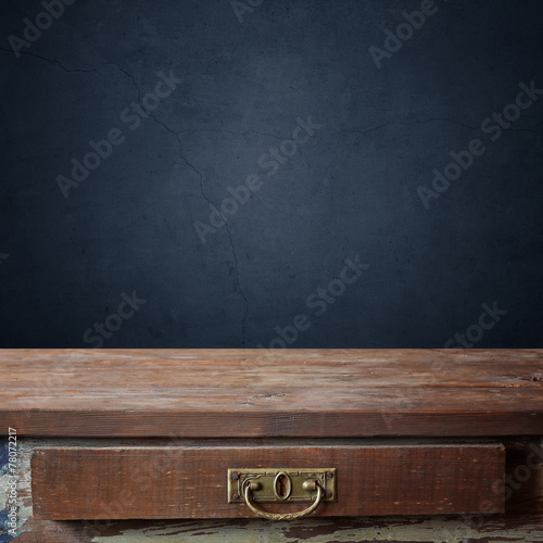 пустой деревянный стол с ящиком на фоне стены
