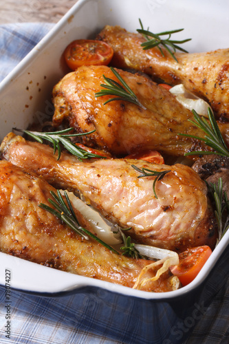 chicken legs with rosemary in a baking dish close-up vertical