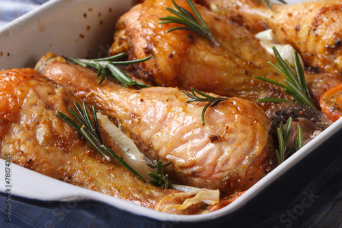 chicken legs with rosemary in a baking dish macro horizontal