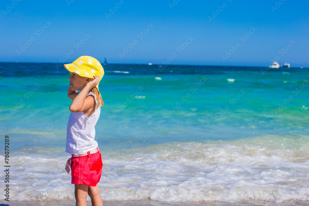 Adorable little girl at white beach during tropical vacation