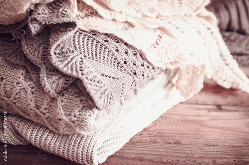 stack of sweaters on a wooden background. vintage toning