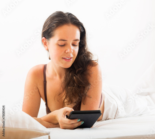 Woman with tablet in bed