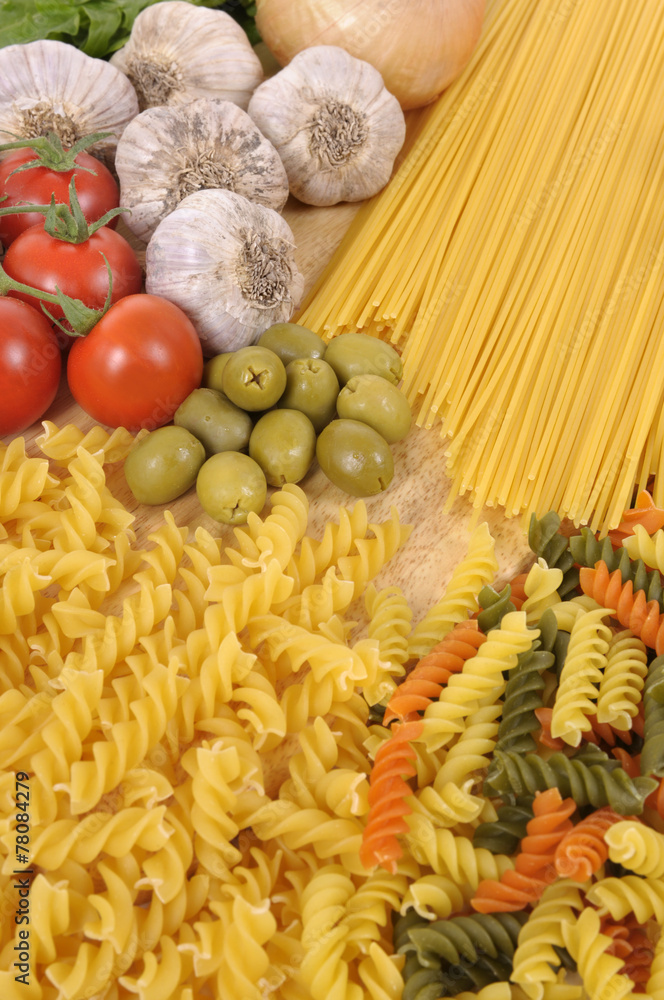 Selection of different spaghetti and pasta with garlic tomato and olives ingredients for cooking photo Selection of different spaghetti and pasta with garlic tomato and olives ingredients for cooking photo
