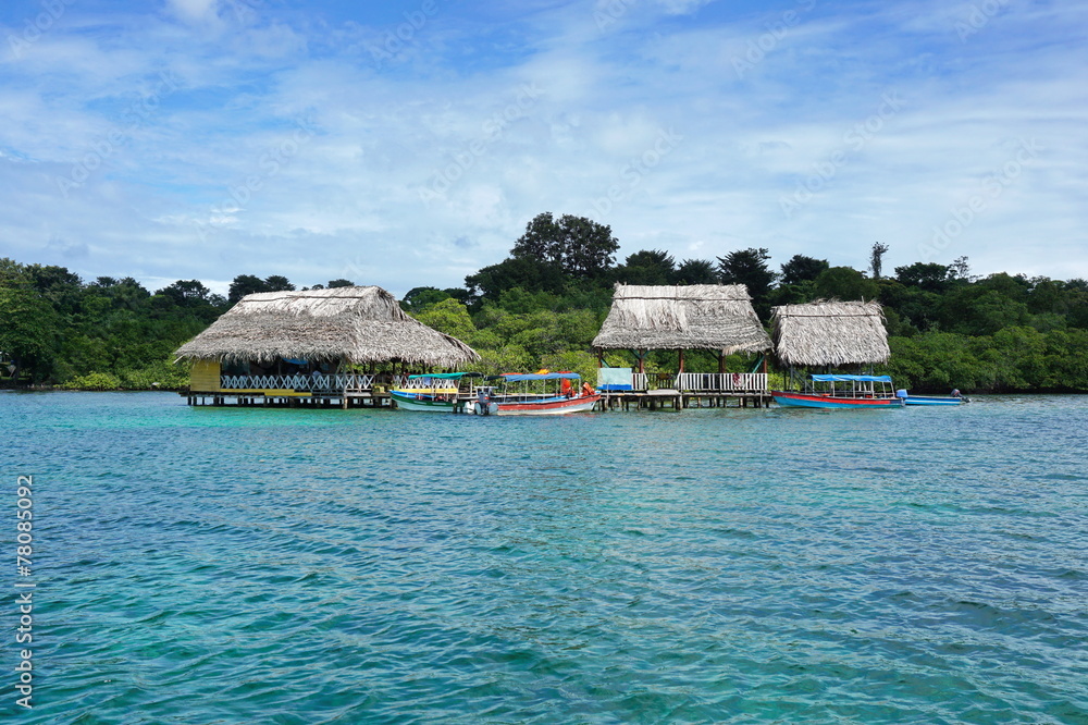 Tropical restaurant with thatched roof over water