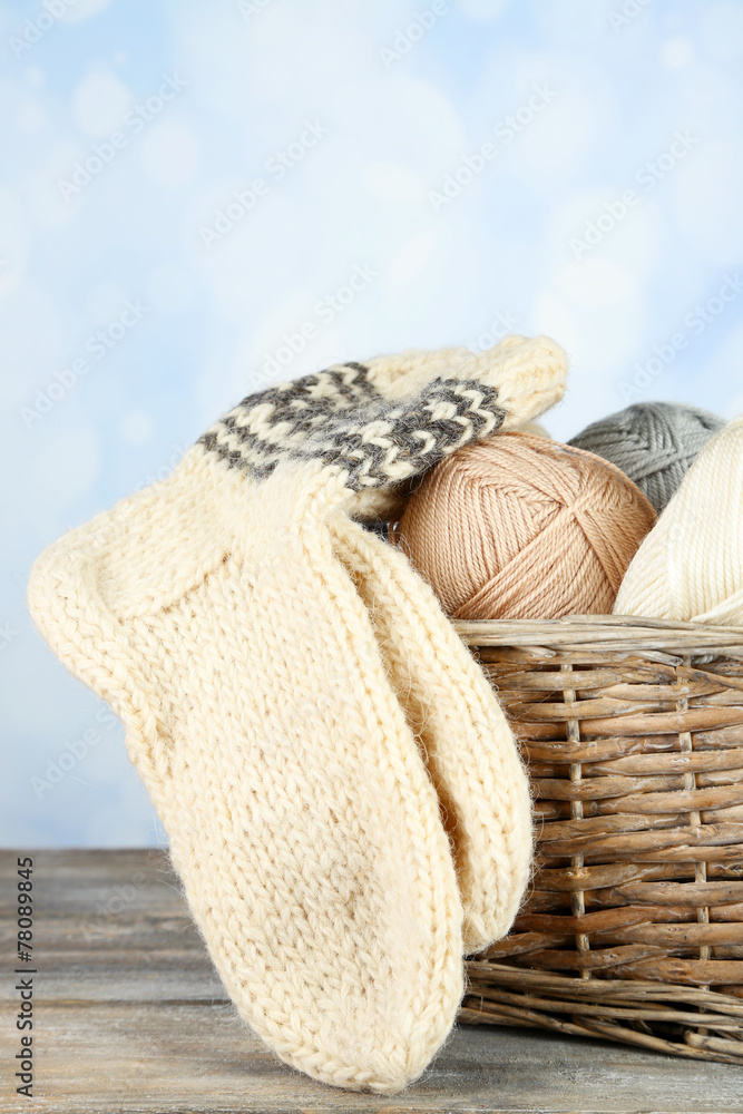 Knitting yarn and socks in basket, on light background