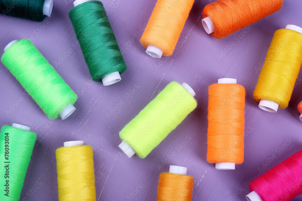 Multicolor sewing threads on wooden background Multicolor sewing threads on wooden background