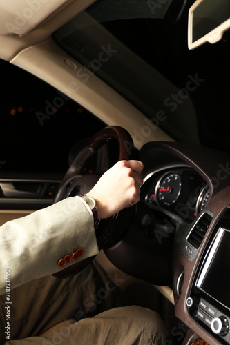 Man driving his modern car at night in city, close-up © Africa Studio