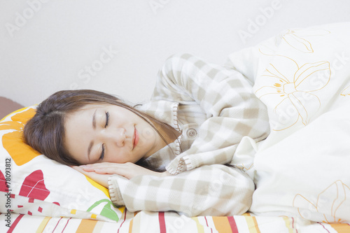 ベッドで寝る女性