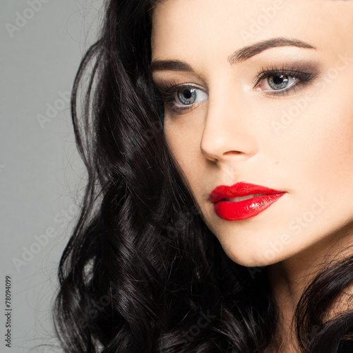 Cute female face with stage makeup smokey eyes and red lips