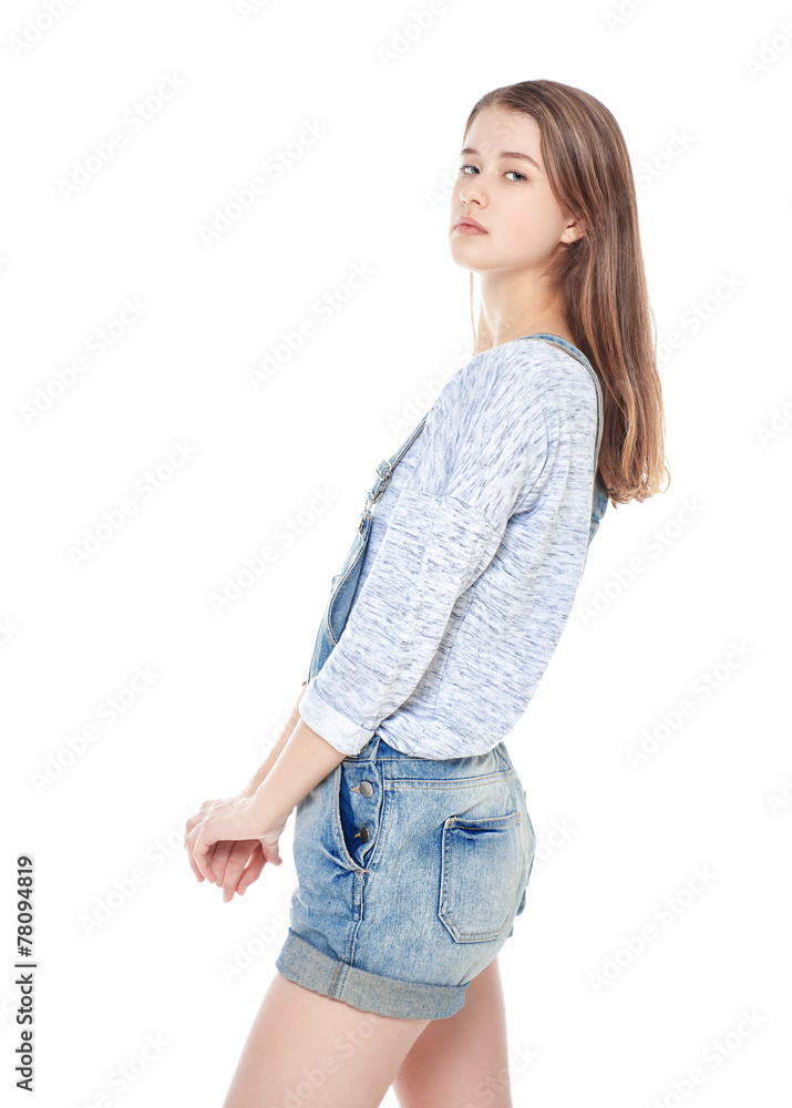 Young fashion girl in jeans overalls posing isolated Young fashion girl in jeans overalls posing isolated