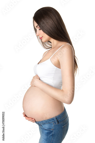 Attractive young pregnant woman holding her belly. photo