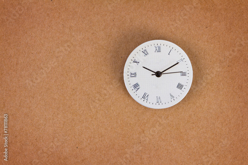 surface of roman number clock on brown paper background